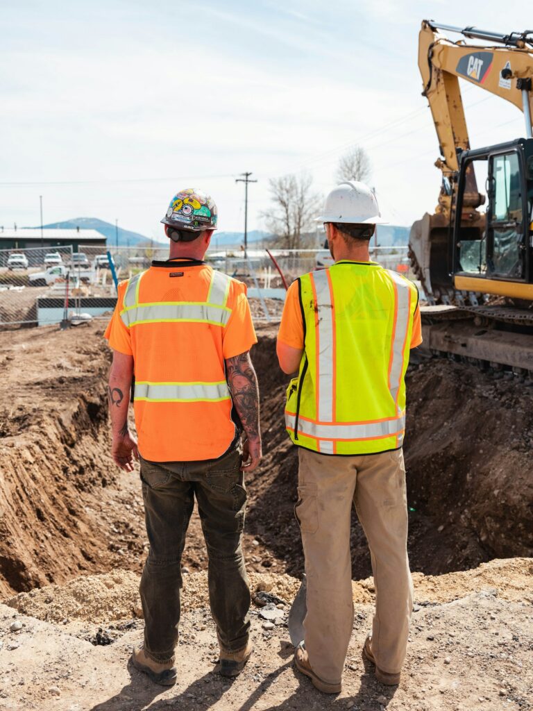 Two workers in hi-vis on a work site